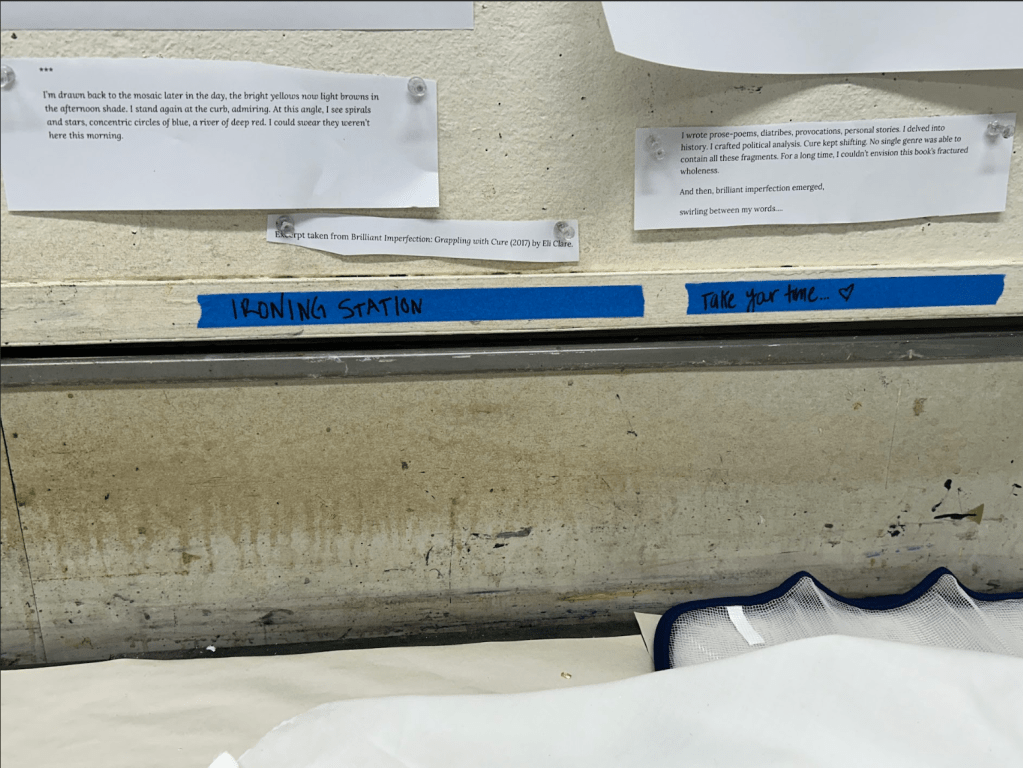 [A photo of the drying station. There are taped up quotes and things to consider while people iron their paper. A piece of tape reads: IRONIN STATION]