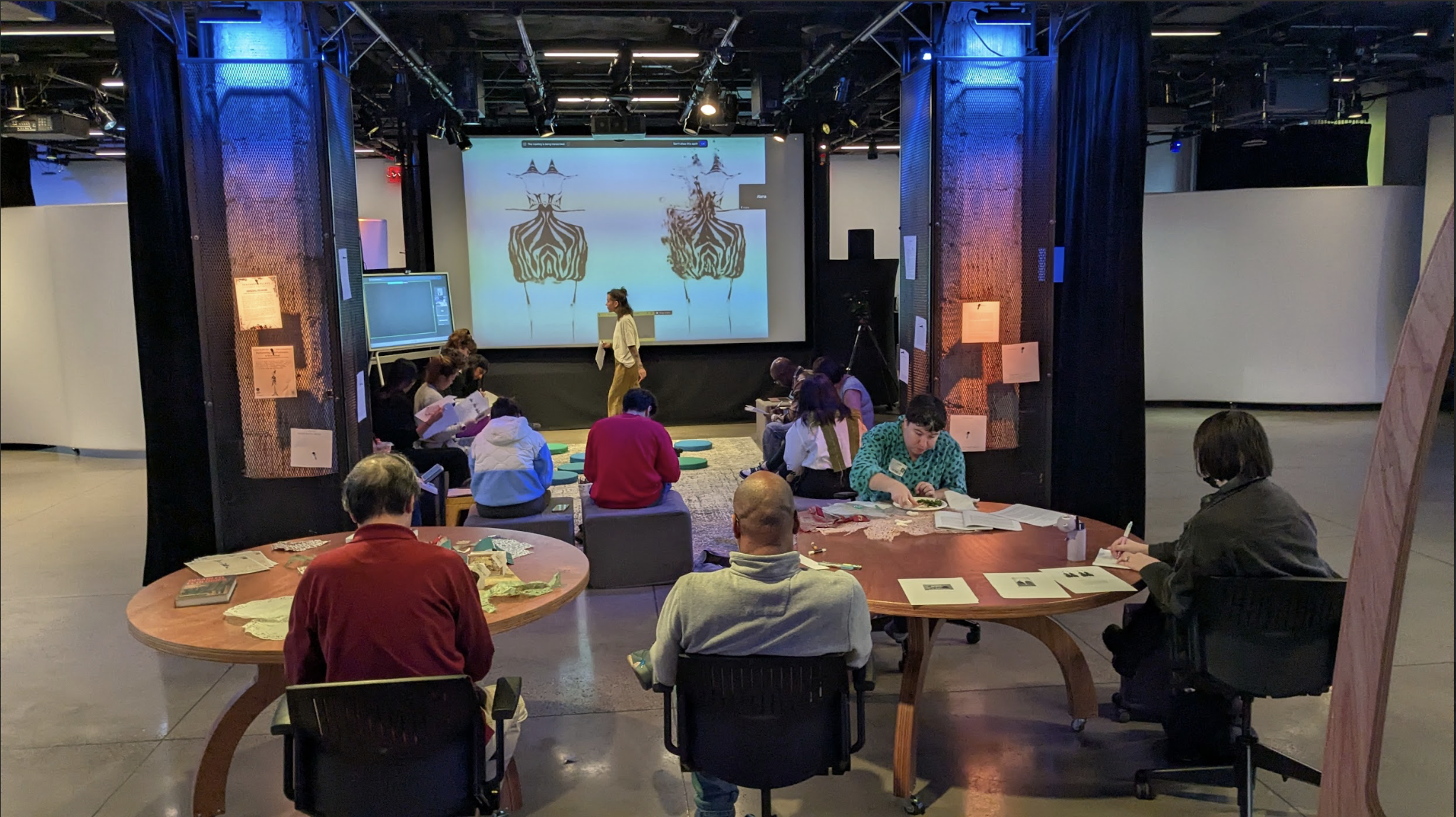 [a photo of participants talking, writing, and thinking with Freds, Maria, and Alana.]
