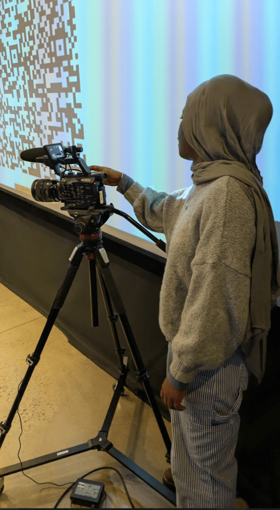 [a photo of Farida, the producer of the event, standing behind the camera.]