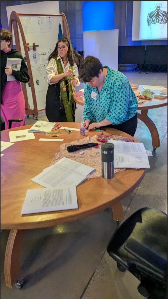 [a photo of participants engaging with footnotes through writing, speaking, and observing.]