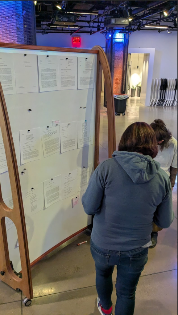 [a photo of a workshop participant adding footnotes to a large whiteboard.]